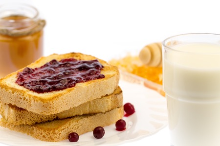 fresh french toast with honey and jam on a white plate with berries on a white background. healthy dietの写真素材