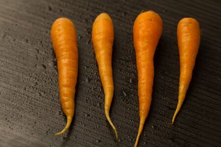 Fresh carrots on a dark brown background. vegetarian foodの写真素材
