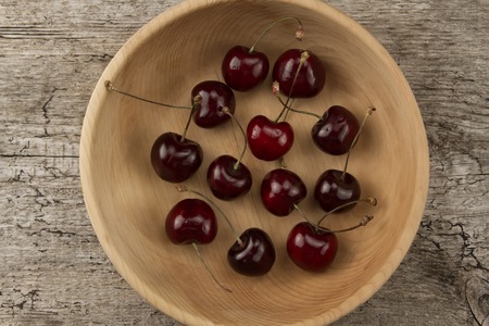 fresh ripe cherry in a wooden plateの写真素材