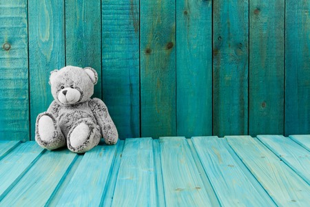 Teddy bear on turquoise wooden background. Baby toysの写真素材