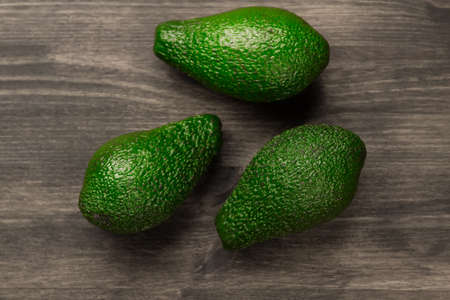fresh avocados on wooden background. Healthy food, diet. Vegetarian.の写真素材