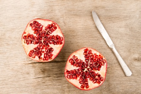 Ripe pomegranate fruit on wooden vintage background. Healthy vegetarian food. Recipe, menu, mock up, cooking.の写真素材