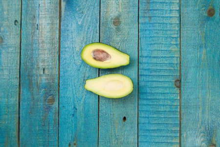 fresh avocados on wooden background. Healthy food, diet. Vegetarian.