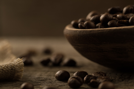 fragrant fried coffee beans. light  burning brightly candles on old wooden background.の写真素材