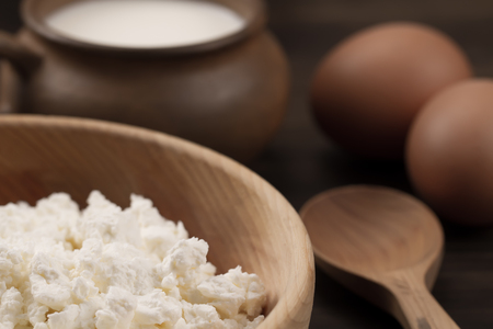 fresh tasty curd in pot on wooden background. Homemade, cottage cheeseの写真素材