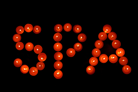 The inscription Spa of red candles on a dark background. Aromatherapyの写真素材
