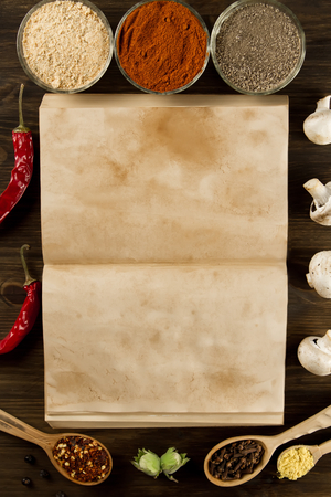 open old vintage book with spices on wooden background. Healthy vegetarian food. Recipe, menu, mock up, cooking.の写真素材