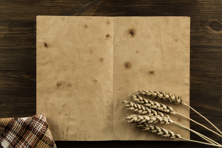 open old vintage book on the aged wooden background. wheat, cloth. Homemade, menu, recipe, mock upの写真素材