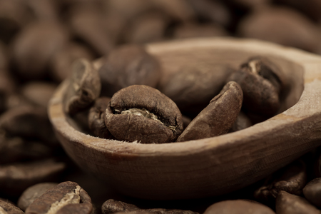 Roasted coffee beans on the plate on wooden background. Top viewの写真素材