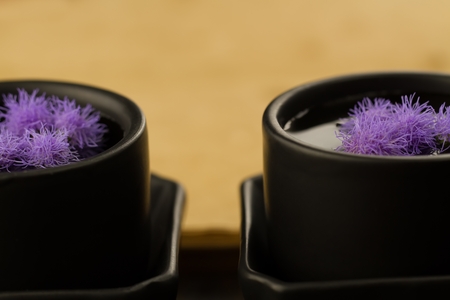 two black Chinese cups with flowers on the background of empty old vintage books. Menu, recipe, mock upの写真素材