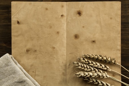 open old vintage book on the aged wooden background. wheat, cloth. Homemade, menu, recipe, mock upの写真素材