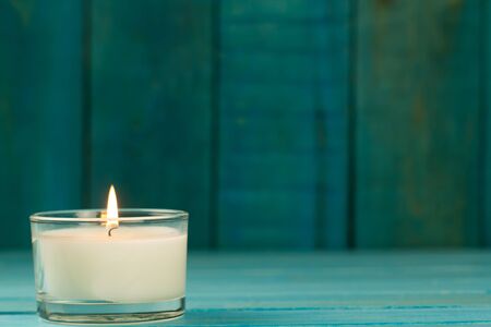 light  burning brightly candles on old wooden background. Spa, meditation, ritual, flavored. turquoise colorの写真素材