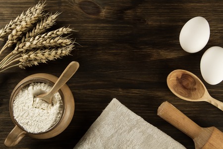 pot of flour, wheat ears, kitchen utensils on wooden background. homemade, menu, recipe, mock upの写真素材