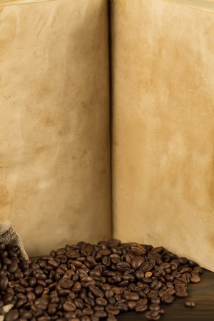 roasted coffee beans on old vintage open book. Menu, recipe, mock up. Wooden background.の写真素材