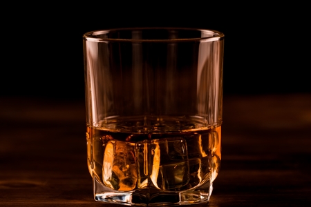 glass of whiskey with ice on a wooden table. Cognac, brandy.の写真素材