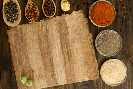 sheet old vintage paper with spices on wooden background. Healthy vegetarian food. Recipe, menu, mock up, cooking.の写真素材