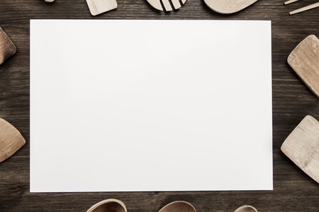 white sheet of paper with utensils on the old wooden background. Mock upの写真素材