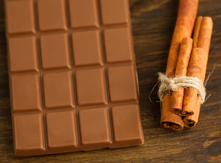 chocolate and cinnamon sticks on wooden backgroundの写真素材