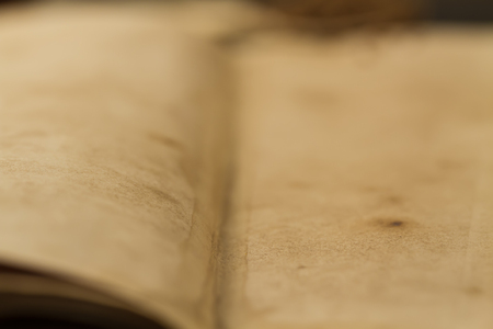 open old vintage book on the aged wooden background. Two clean sheet of paper.の写真素材