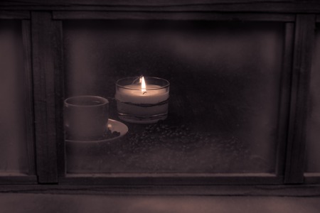 Winter window. Cozy room. Candlesticks on a windowsill. Coffee Cup and roasted coffee beans.の写真素材