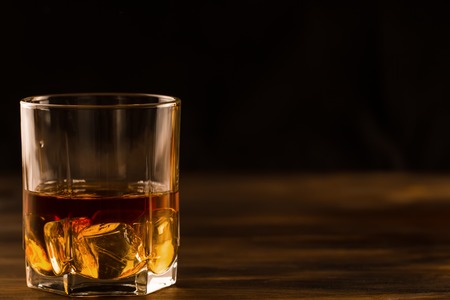 glass of whiskey with ice on a wooden table. Cognac, brandy.の写真素材