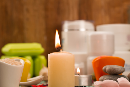 Spa composition with sea salt, candles, soap, shells, creams for face on wooden background. Aromatherapy.の写真素材