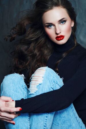 Girl with long curly hair in a black turtleneck.の写真素材