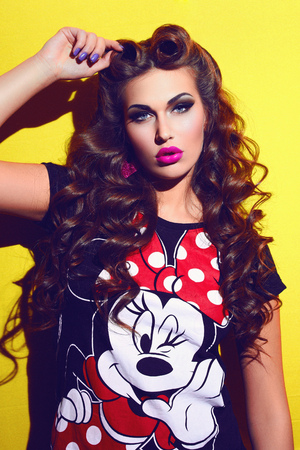 The girl on a yellow background. The girl's face. Girl in a t-shirt Mickey Mouse. Mottled Photo. Punk retro.のeditorial素材