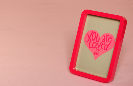 Red photoframe with text in heart pink backgroundの写真素材