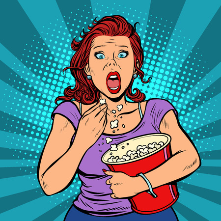 Woman watching a scary movie and eating popcornの写真素材