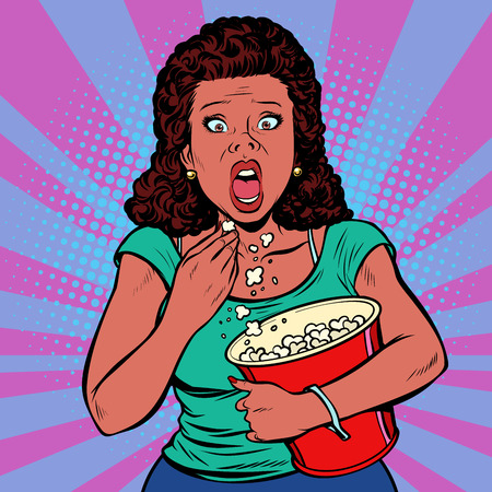Woman watching a scary movie and eating popcornの写真素材