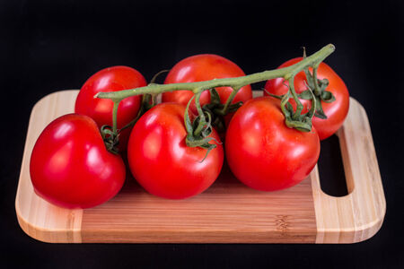 bunch of tomatoes on a cutting boardの写真素材