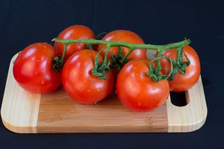 bunch of tomatoes on a cutting boardの写真素材