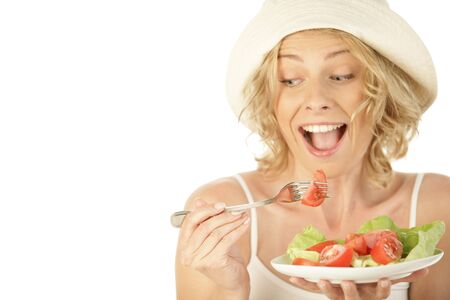 Blonde woman eating vegetable salad isolated on white backgroundの写真素材