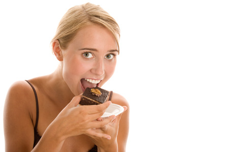 Young woman eating cakeの写真素材