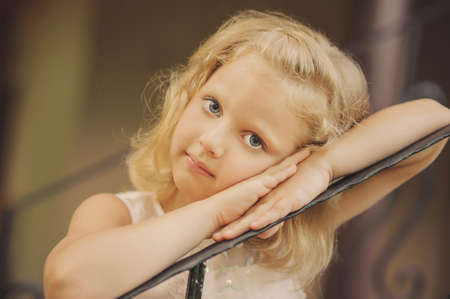 portrait of a girl with blond hair, her hand near face