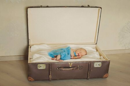 Cute newborn baby is  sleeping in a suitcase. Have a nice dreams baby.の写真素材