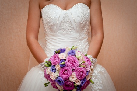 Beautiful wedding bouquet in hands of the bride. Stylish bride with a bouquet of pink roses.の写真素材