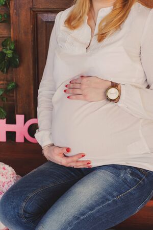 Pregnant woman hugs her belly. A woman waiting for a child.