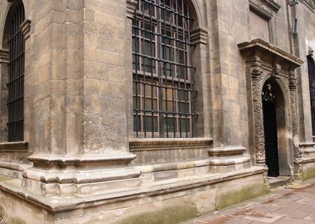 Facade of an ancient building with door and a window with a lattice.の写真素材