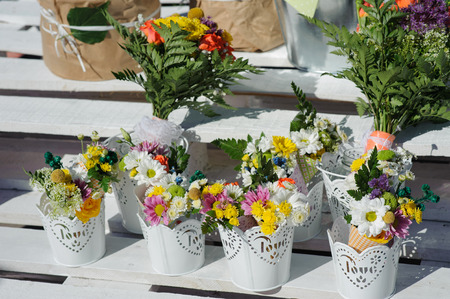 Buckets of beautiful purple and white flowers prepared for wedding ceremony or another festive event. Decorate
