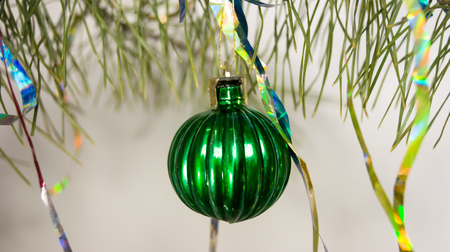 green Christmas ball close-up on a pine branchの写真素材