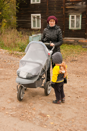 girl with a stroller near a wooden houseの写真素材