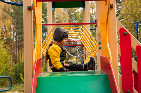 baby sitting on a children's slideの写真素材
