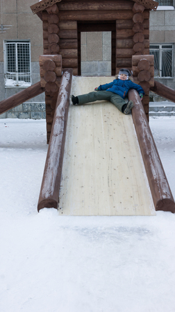 boy riding a wooden slideの写真素材