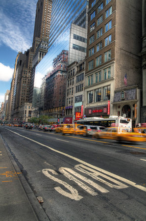 Manhattan, New York, United States - 19 August 2014 : Busy street in the center of Manhattan with large buildings and blue skyのeditorial素材