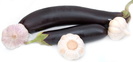 Eggplant on a white background with heads of garlicの写真素材