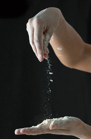 Flour hands on a black backgroundの写真素材