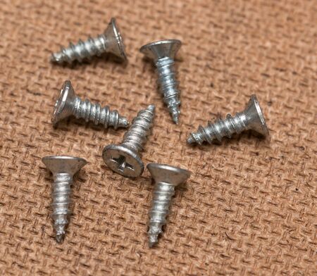 nails and screws on a wooden background