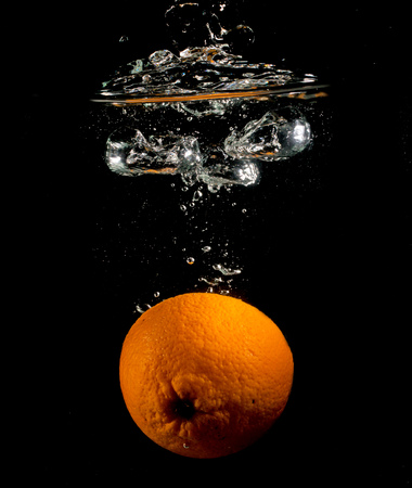 orange in water on a black backgroundの写真素材